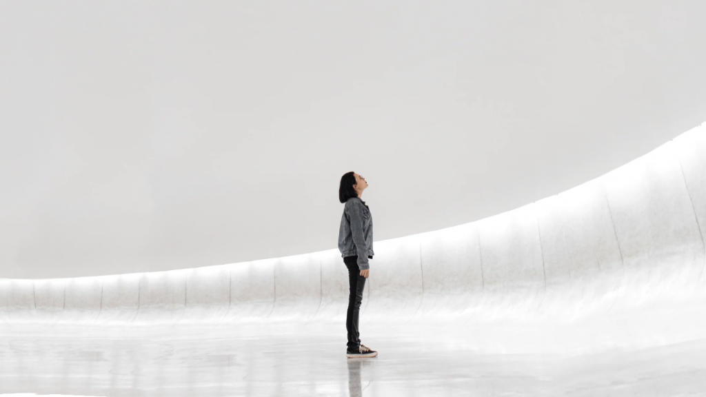 Woman in white room looking upwards, demonstrating the expansiveness of innovation culture